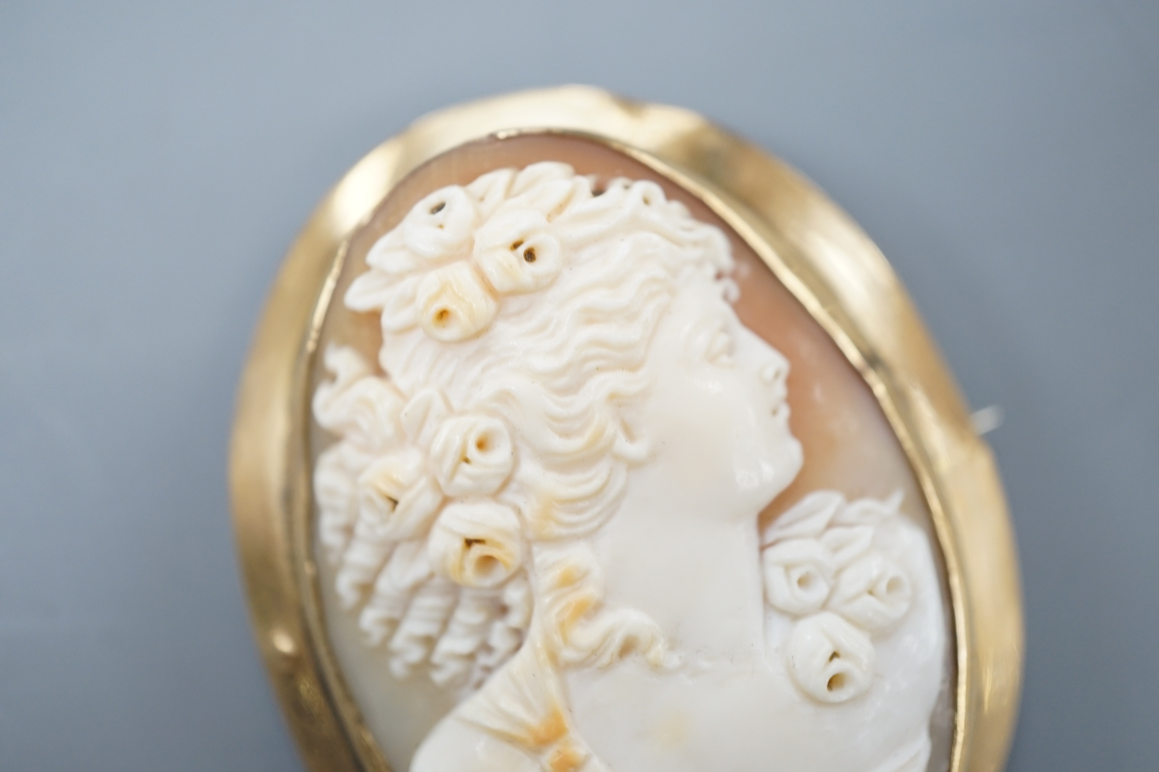 A yellow metal mounted oval cameo shell brooch, carved with the bust of a lady to sinister, 51mm, gross 16 grams.